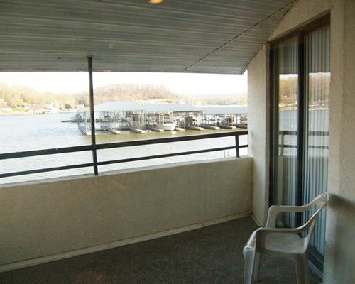 A balcony with patio furniture and view of a marina in the lake.