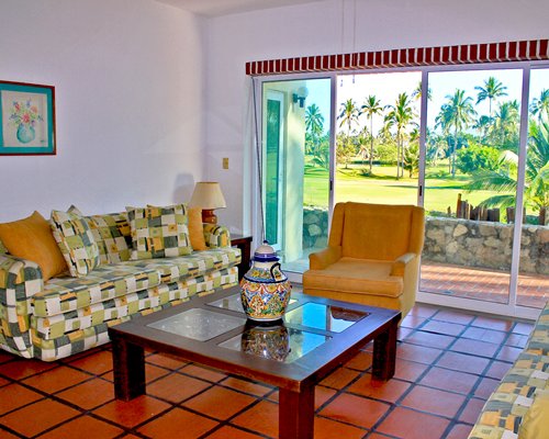 A well furnished living room with pull out sofa and a patio.