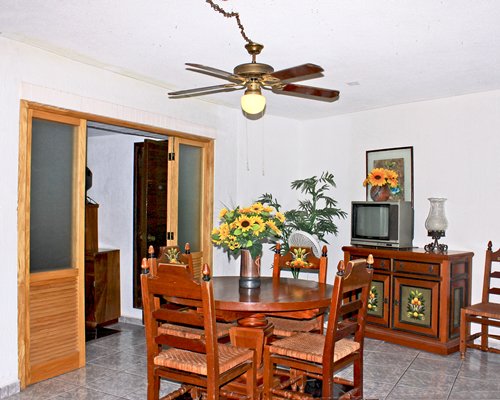 A well furnished wooden dining area with a television.