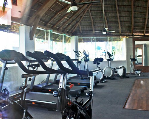 A well equipped indoor fitness center with an outside view.