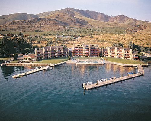 A lake with piers leading from the Peterson's Waterfront Resort alongside the mountains.