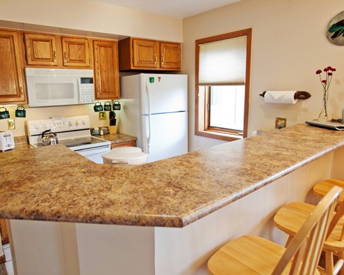 An open plan kitchen with breakfast bar and outside view.