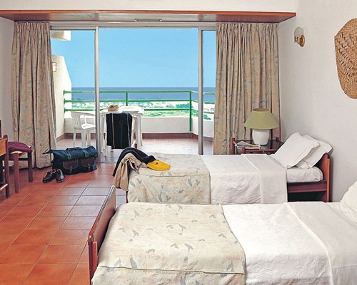 A well furnished bedroom with two beds and a balcony.