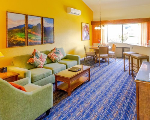 A WELL FURNISHED LIVING ROOM WITH A BALCONY AND PATIO FURNITURE.