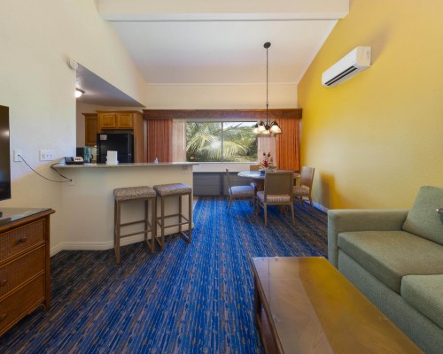 A WELL EQUIPPED KITCHEN WITH BREAKFAST BAR AND AN OUTSIDE VIEW.