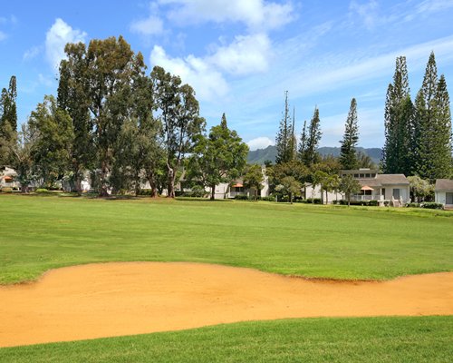 A golf course surrounded by wooded area.