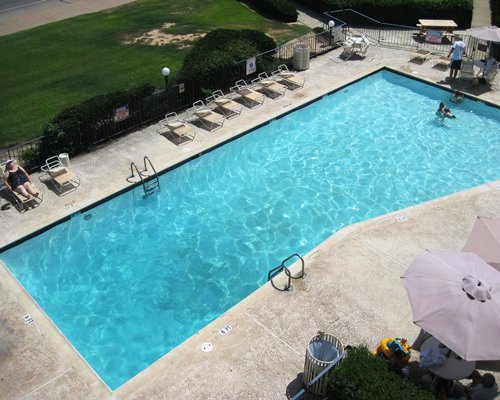 A view of an outdoor swimming pool with chaise lounge chairs.