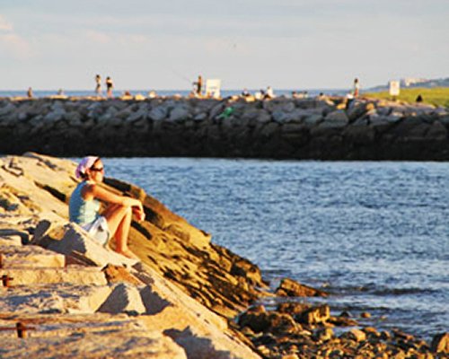 A women sitting on the rock stone beach.