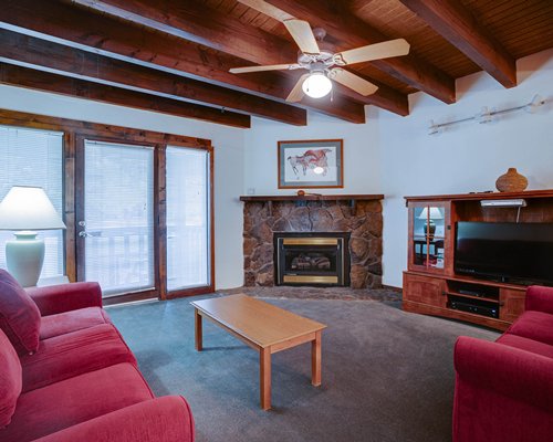 A well furnished living room with dining area open plan kitchen breakfast bar and a stairway.