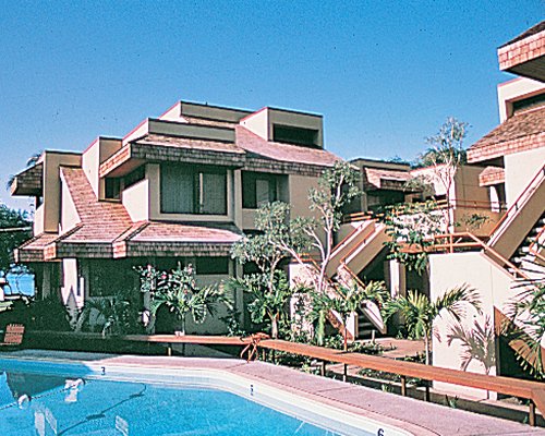 An outdoor swimming pool alongside multiple resort units.