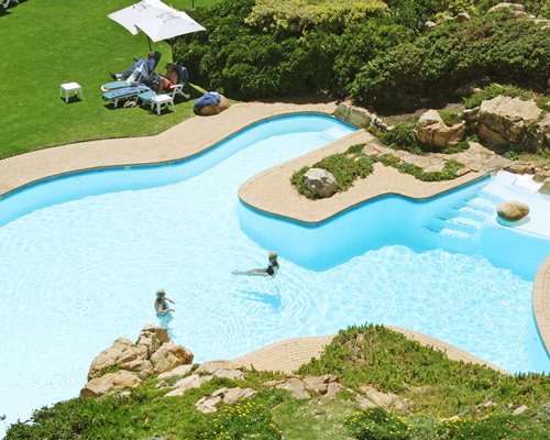 An outdoor swimming pool with patio furniture.