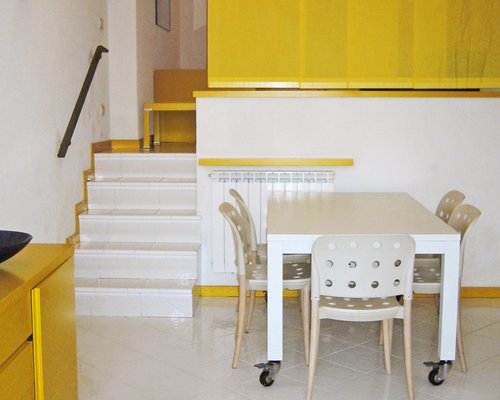 A well furnished dining table alongside a stairway.