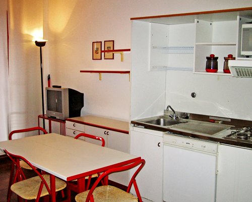 An open plan kitchen with a dining area and television.