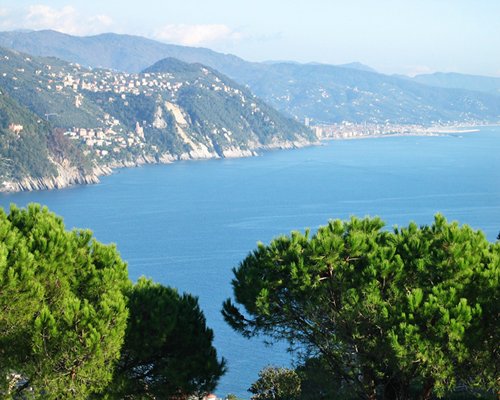 View of the ocean alongside mountains with wooded area.