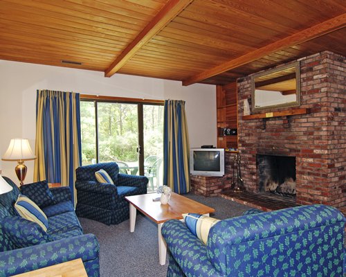 A well furnished living room with a television fireplace and patio.