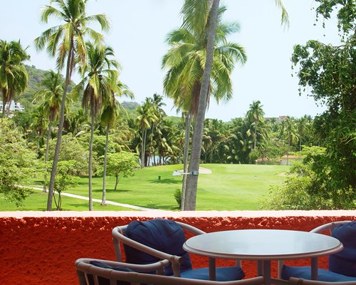 Balcony with patio furniture with view of a landscaped pathway.