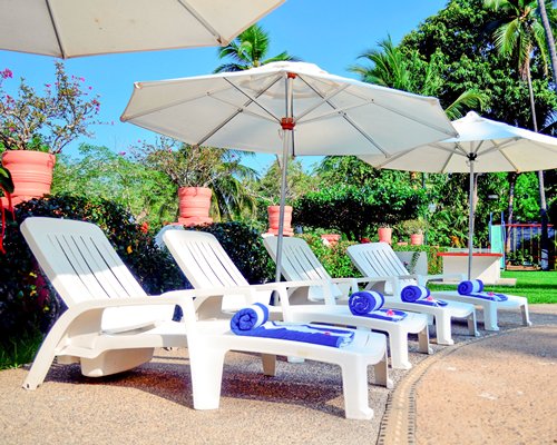 Scenic view of chaise lounge chairs and thatched sunshades.