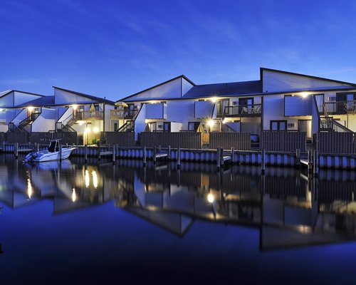 An exterior view of multiple resort units alongside the ocean at night.