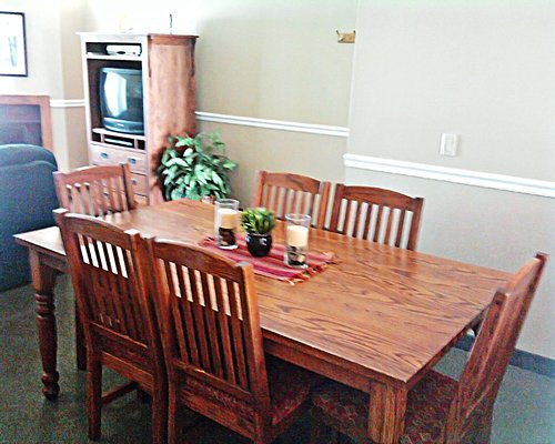 A well furnished dining room alongside a television.