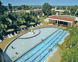 A view of an outdoor swimming pool with chaise lounge chairs alongside the resort unit.