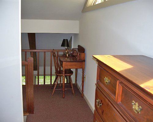 An indoor balcony with a cupboard and a table.