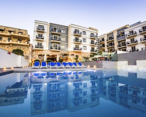 An outdoor swimming pool with chaise lounge chairs.