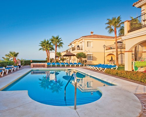 Outdoor swimming pool with plenty of chaise lounge chairs steps from the units.