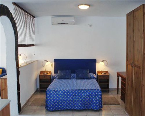 A well furnished bedroom with bed and lamps.