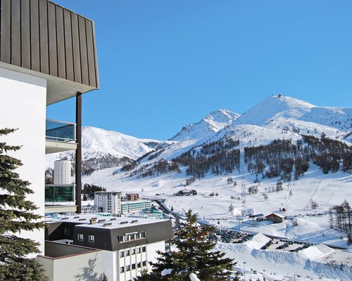 An exterior view of the Palace Residence alongside a snowy mountain.