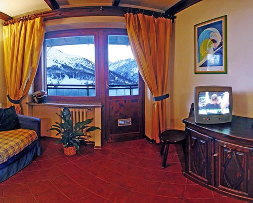 A well furnished living room with television and outside view.