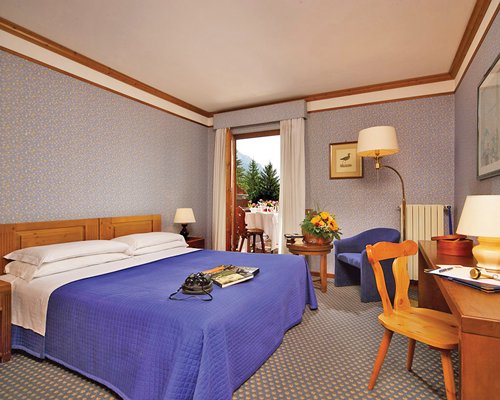 A well furnished bedroom with an outdoor patio and study table.