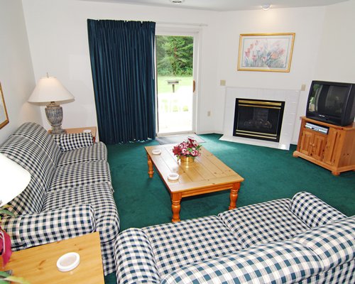 A well furnished living room with a television and a fireplace.