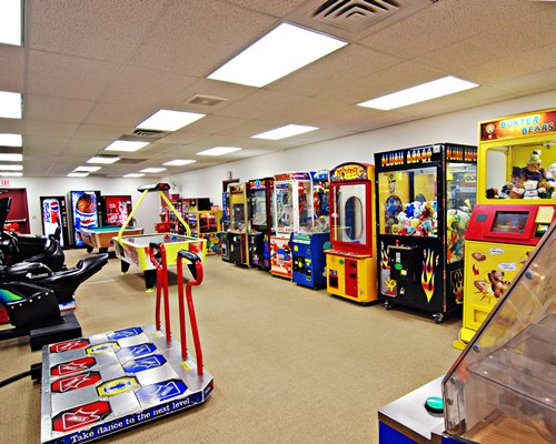 An indoor recreation room with pool table and arcade games.
