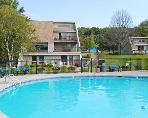 An outdoor swimming pool with patio furniture alongside resort units.