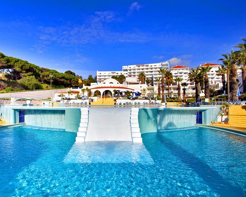 A view of an outdoor swimming pool alongside Oura View Beach Club resort.