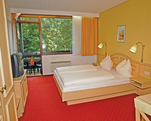 A well furnished bedroom with a television and an outside view.
