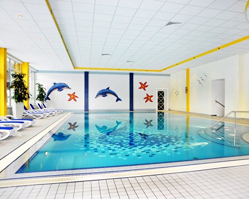 Indoor swimming pool with chaise lounge chairs.