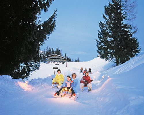 Kids sliding in a wooden sled during winter.
