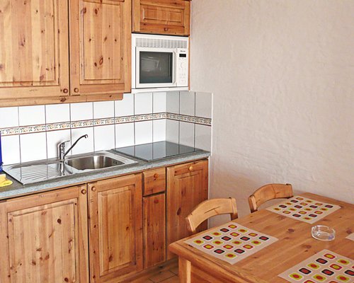 A well equipped kitchen with a wooden dining table.