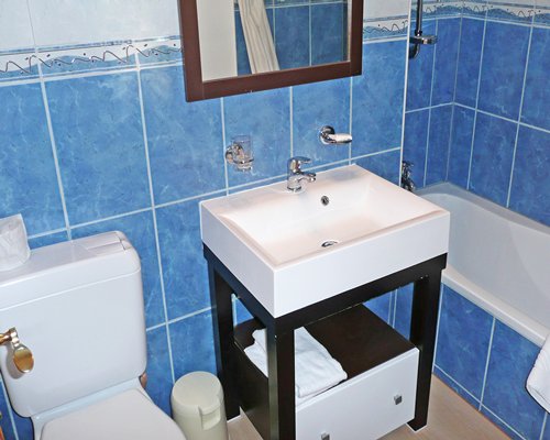 A bathroom with bathtub and single sink vanity.