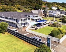 Exterior view of the resort with an outdoor swimming pool patio furnitures and sunshades.