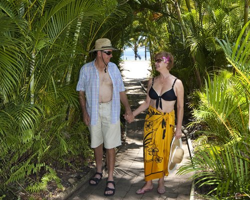A couple walking on the landscaped pathway from the beach.