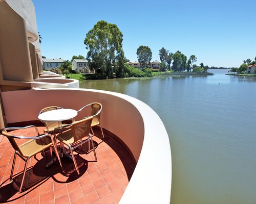 View of the water and buildings from the balcony with patio furniture.