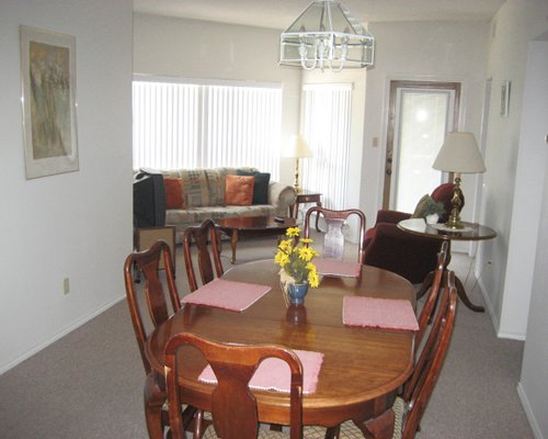 A well furnished living room with television and dining area.