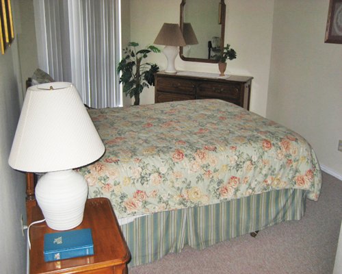 A well furnished bedroom with vanity and lamp.
