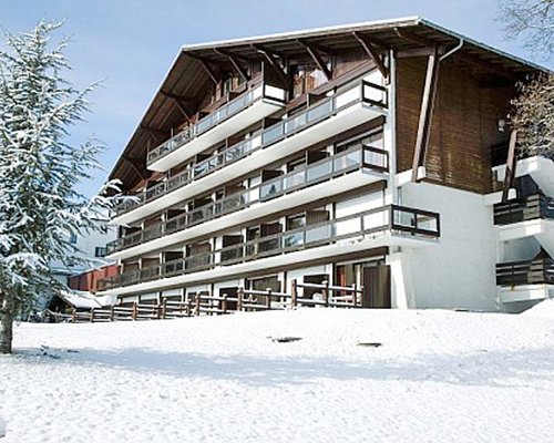 A street view of the Maeva Clubhotel Megeve Mont D'Arbois covered in snow.