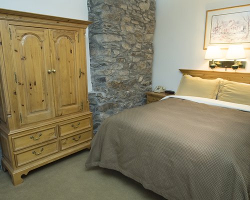 A well furnished bedroom with queen bed and wardrobe.