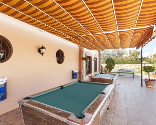 Outdoor recreation area with pool tables and ping pong.
