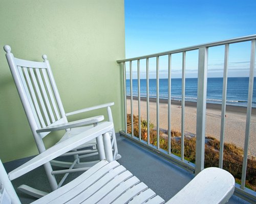 Balcony with patio chairs and ocean view.