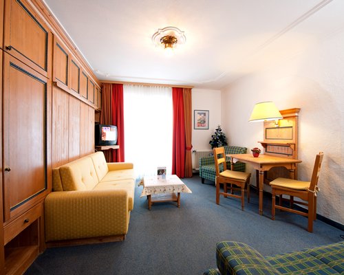 A well furnished living room with a television dining area and outside view.